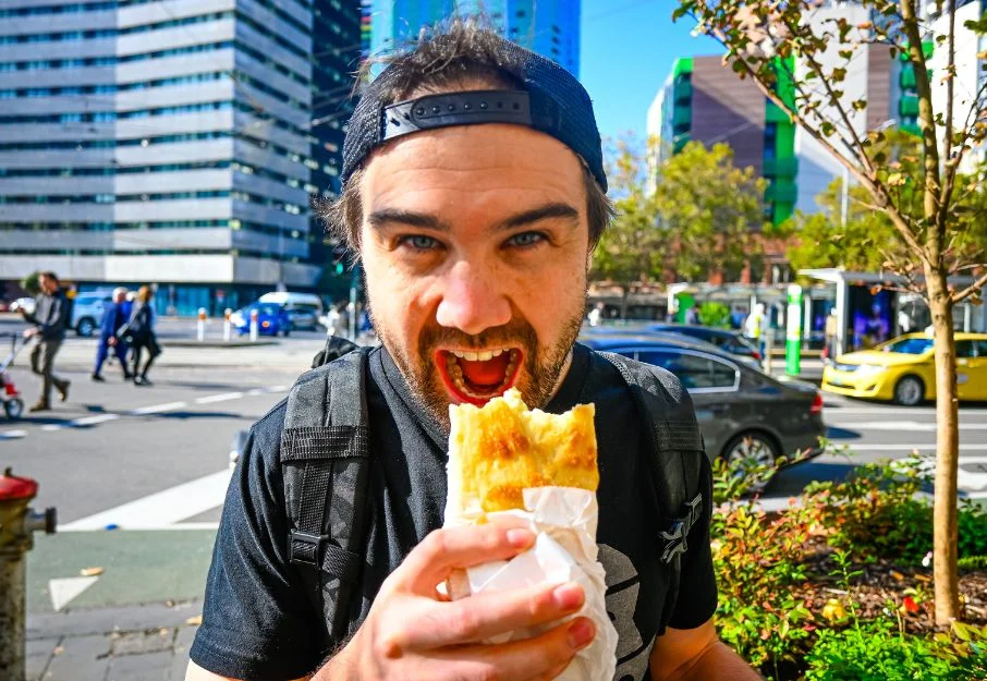 Man eating borek from Victoria Market in Melbourne
