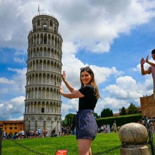 Woman holding up the leaning tower of pisa after leaving baggage at Radical Storage
