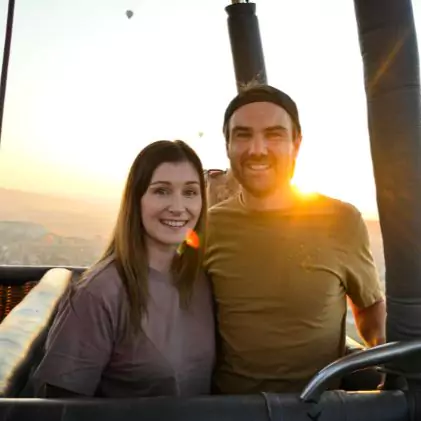Couple hot air ballooning in Cappadoccia with sunrise in background
