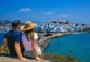 Couple sitting on rock overlooking Naxos, Greece while on holiday for one year.