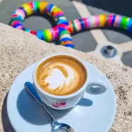 Italian coffee on table with colorful art in background